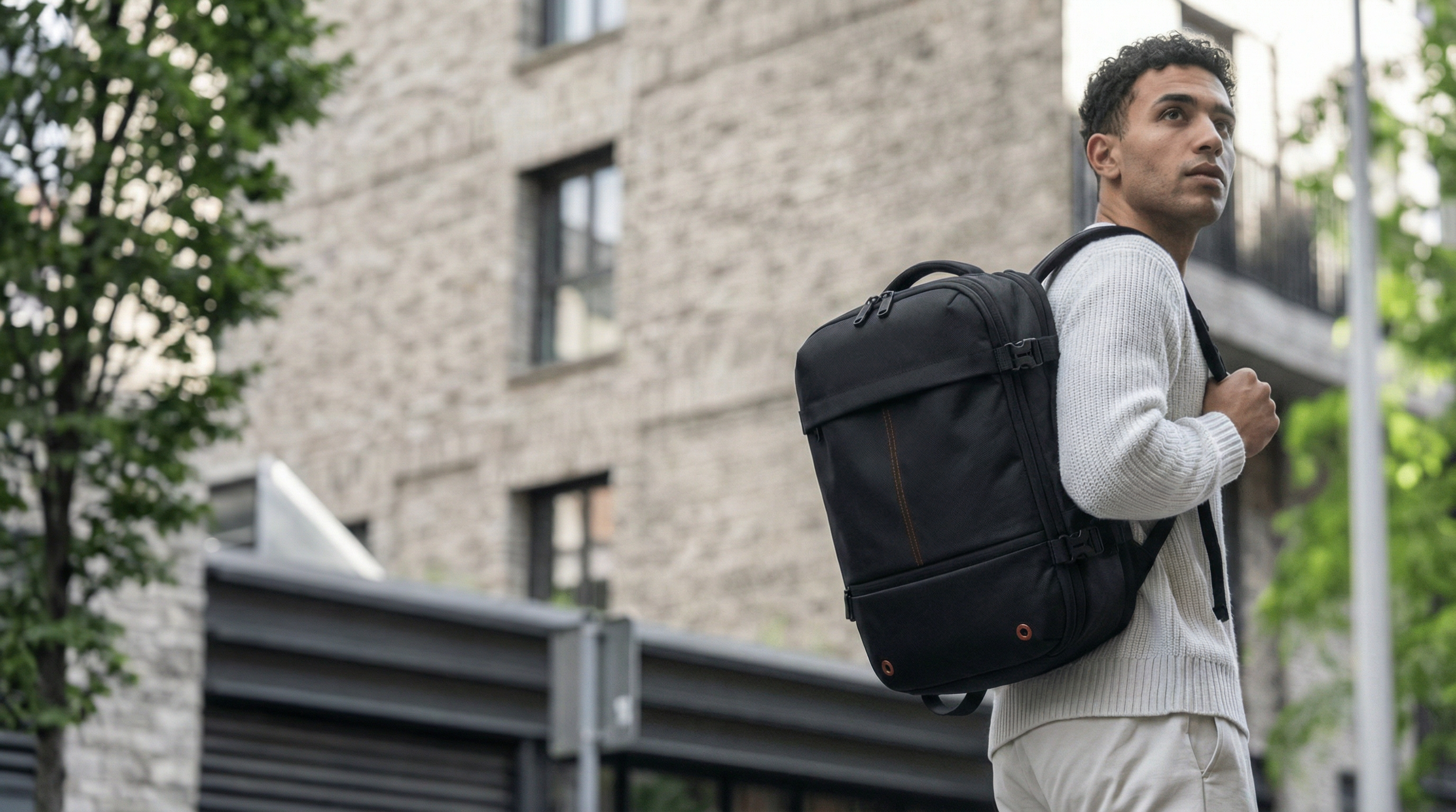 Man walking outdoors with a origin backpack in an urban setting